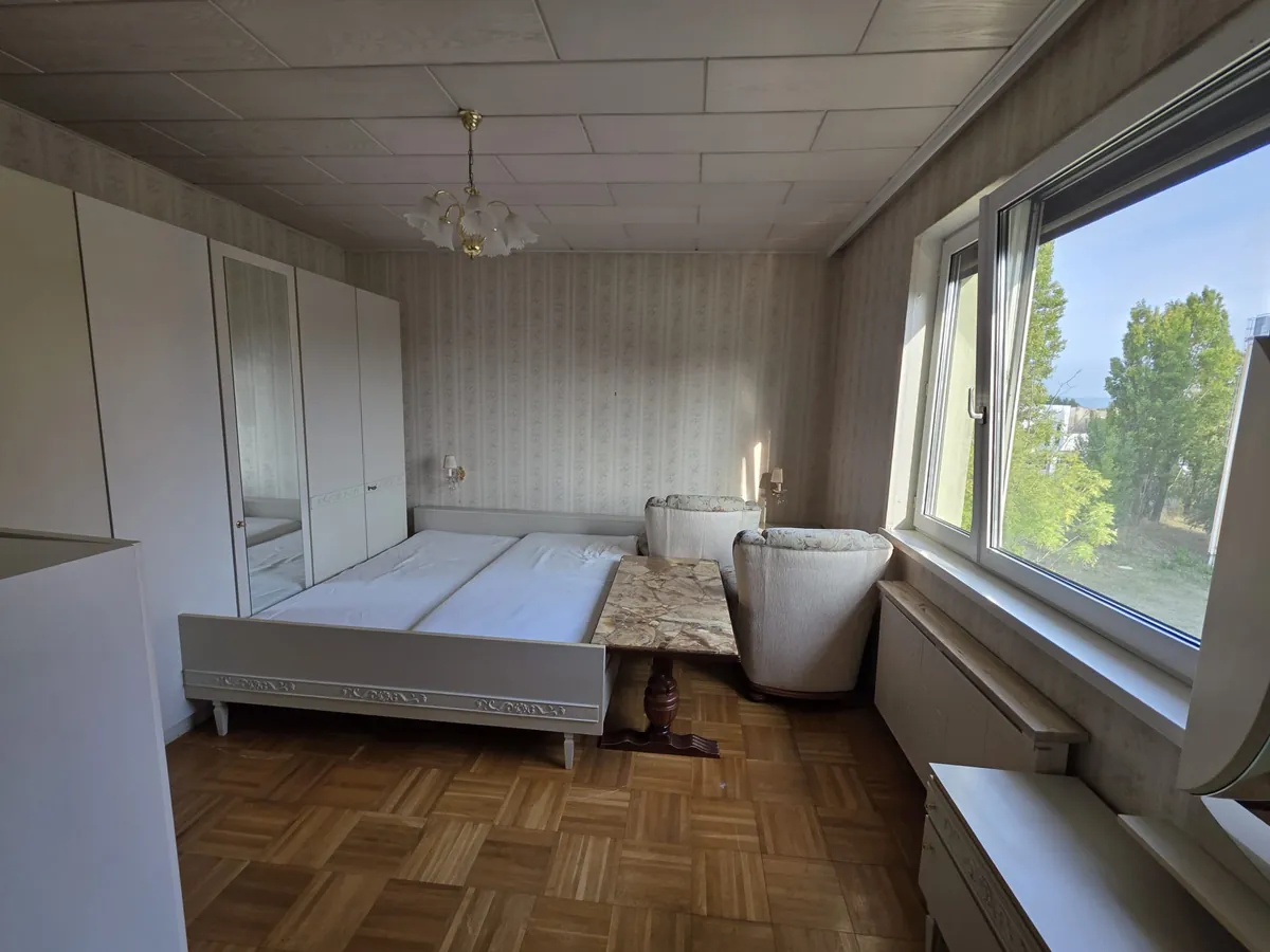 Individuelle Planung einer Entrümpelung in Baden – möbliertes Schlafzimmer mit Doppelbett, Kleiderschrank und zwei Sesseln vor der Räumung